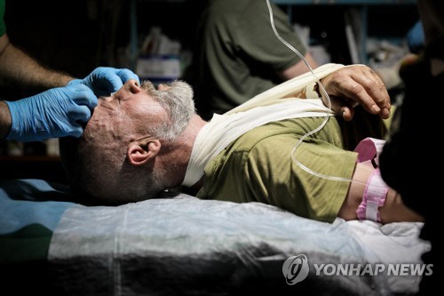 우크라이나 전선 바흐무트에서 한 우크라이나 군인이 의무대로부터 치료를 받고 있다. [EPA=연합뉴스 자료사진]